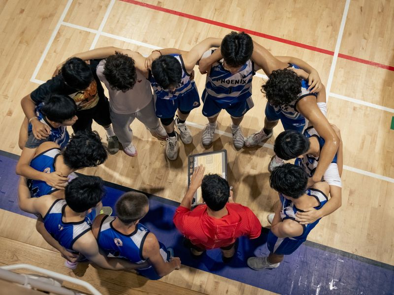 Coach donnant ses consignes à son équipe en cercle
