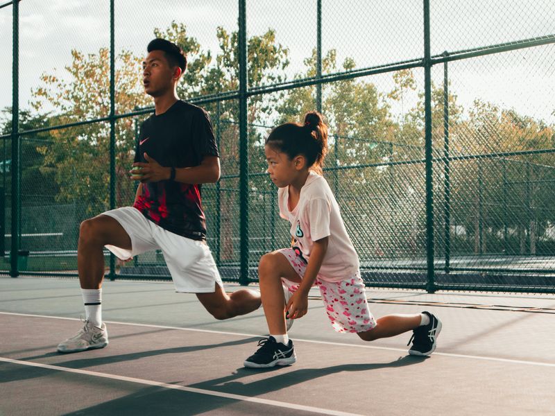 Adulte accompagnant une jeune sportive à l'entraînement